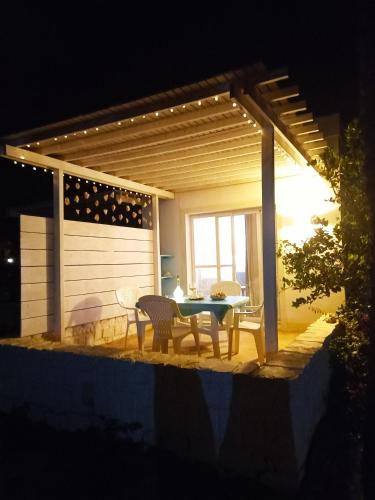 a table and chairs on a patio at night at Beach house Agua Viva, Praia de Chaves, Boa Vista, Sal Rei, Cape Vert, 50mt spiaggia in Cabeçadas