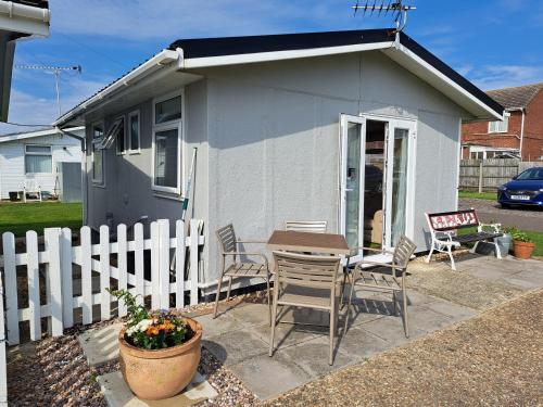 a small white house with a table and chairs at Beside the Sea Chalet, Mablethorpe in Mablethorpe
