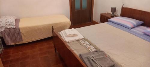 1 dormitorio con 2 camas y portaequipajes en Casa Nicola, en Rapone