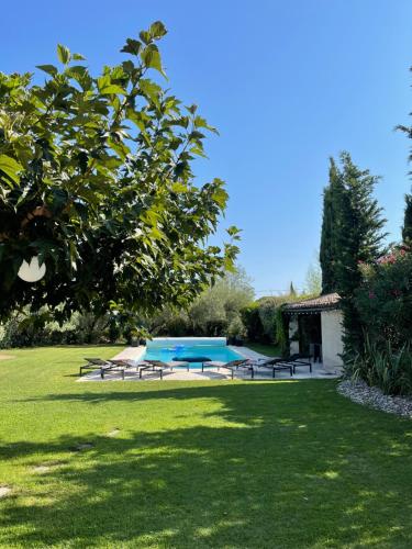 un parc avec des tables de pique-nique et une piscine dans l'établissement Villa privée Cayan, à Saint-Rémy-de-Provence
