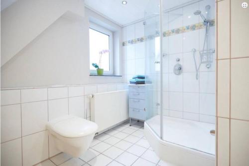 a bathroom with a toilet and a tub and a sink at Ferienwohnung Tannen-Apotheke Zwei in Mengerskirchen