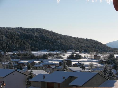 a town with snow covered roofs and a mountain at La Pradella in Bolquere Pyrenees 2000