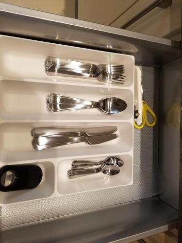 a drawer filled with silver utensils in a refrigerator at London Luxury Apartments 1 min from Redbridge Station with Parking in Wanstead