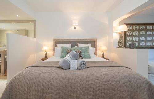 a bedroom with a large bed with two pillows at Hôtel Font Mourier in Cogolin