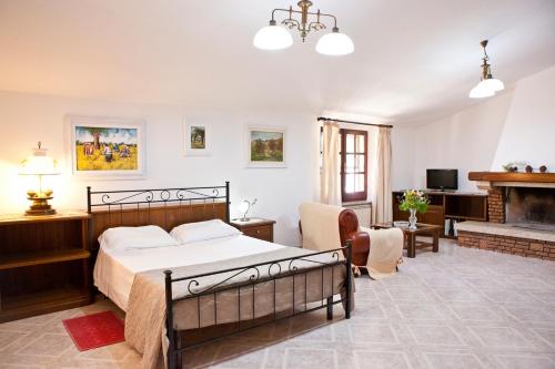1 dormitorio con 1 cama y sala de estar con chimenea en Casa vacanze Maria Maddalena 1 Iglesias en Iglesias