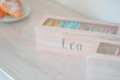 a wooden box with the word tea written on it at Nùe Rooms in Cagliari