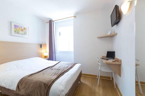 sypialnia z łóżkiem i biurkiem z laptopem w obiekcie Europe Hotel Vieux Port w Marsylii