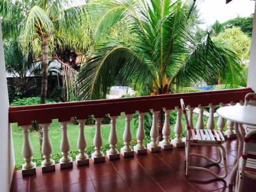 a balcony with a white fence and palm trees at Apartotel Flamboyant in Jacó