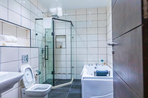a bathroom with a toilet and a sink and a shower at Isglo Hotels Ikoyi in Lagos