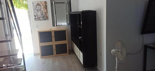 ein Wohnzimmer mit einem schwarzen Kühlschrank und einem Ventilator in der Unterkunft Casa MIRADOR con vistas a toda la ciudad in Córdoba