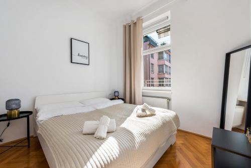a white bedroom with a bed with towels on it at A&S Center Apartment Vienna in Vienna