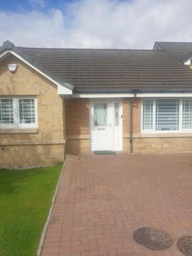 a house with a white door and a brick driveway at Yementry court in Cambuslang