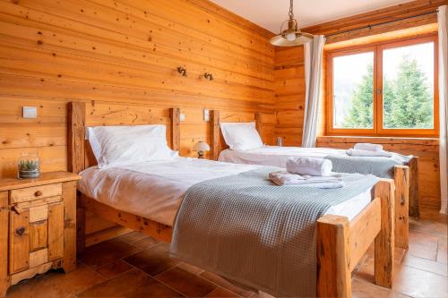 une chambre avec deux lits dans une cabane en rondins dans l'établissement Apartment Petit Togadere, aux Gets