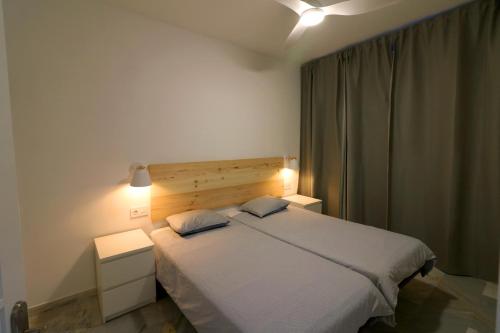 una camera con un letto bianco con due cuscini di Altamira ocean views one bedroom ad Adeje