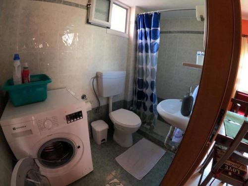 a bathroom with a washing machine and a sink at Anna’s house in Síndos