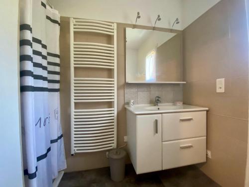 ein Bad mit einem Waschbecken und einem Spiegel in der Unterkunft Gîte tout confort entre Marmande et Tonneins in Birac-sur-Trec