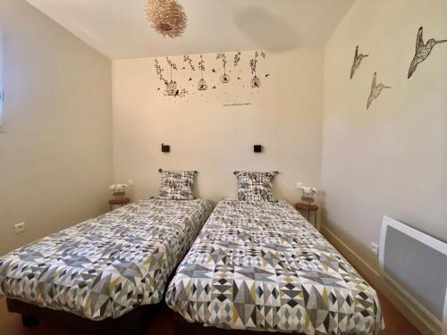 um quarto com uma cama com um edredão em Gîte tout confort entre Marmande et Tonneins em Birac-sur-Trec