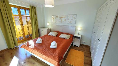 een slaapkamer met een bed met twee handdoeken erop bij Apartamenty 4 Góry in Szczyrk