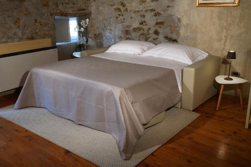 a bedroom with a large bed with white sheets and pillows at Cà 'd Calin Casa nel Borgo in Serralunga d'Alba