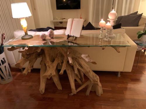 een salontafel gemaakt van hout met een glazen top bij Maison de Maff in Pesaro