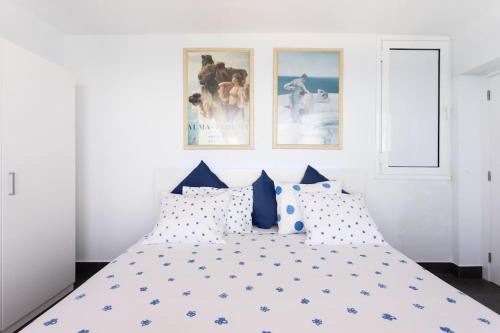 um quarto com uma cama com almofadas azuis e brancas em Wish you were here em Puerto de la Madera