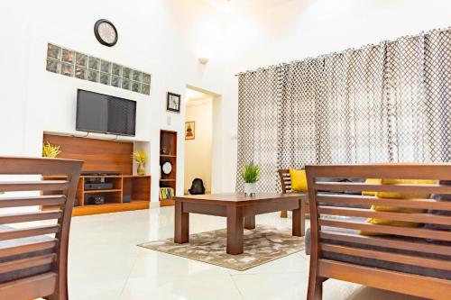 a living room with a tv and a table and chairs at Lovely 4 Bedroom Solar Powered House with CCTV and Unlimited WiFi near Devtraco Court Community 25 Tema in Tema