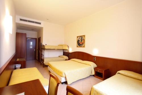 a hotel room with two beds and a table at Garda Family House in Brenzone sul Garda