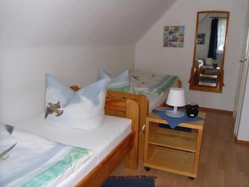een kleine kamer met 2 bedden en een spiegel bij Ferienwohnung Lachmöwe in Heringsdorf