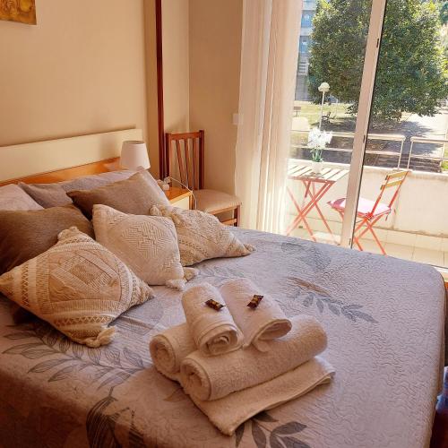 uma cama com toalhas e uma janela em Bonito piso con garaje y piscina a 8 'centro em Castro-Urdiales