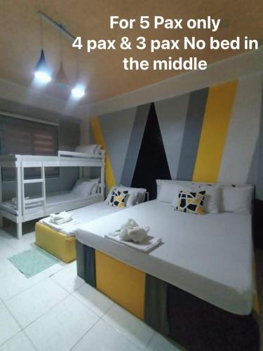 a room with two beds and a bunk bed in it at DJCI Apartelle with kitchen n bath 105-104 in Cabanatuan