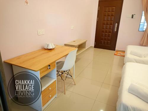 um pequeno quarto com uma secretária e uma cama em Chakkai Village Living Guest House em Kuala Perlis
