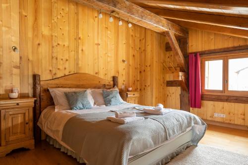 une chambre avec un lit dans un mur en bois dans l'établissement Chalet Grand Togadere, aux Gets