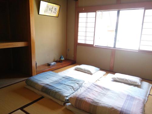 um quarto com uma cama com duas almofadas em Matsuo House - Max 3 person Room Haru em Zao Onsen