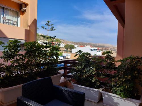 d'un balcon avec des plantes en pot et une vue sur la ville. dans l'établissement Appartement pied dans l'eau imi Ouaddar, à Agadir nʼ Aït Sa
