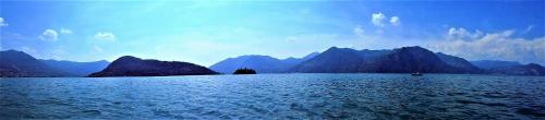 a large body of water with mountains in the background at Dock House in Marone