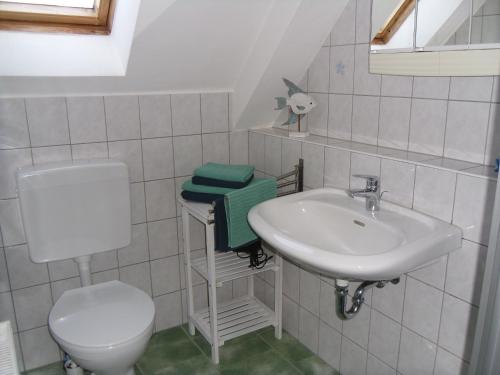 een witte badkamer met een wastafel en een toilet bij Ferienwohnung Lachmöwe in Heringsdorf