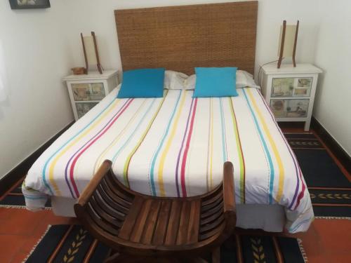 um quarto com uma cama e uma cadeira de madeira em Apartment over the Ocean em Sesimbra