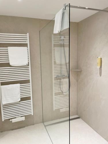 a bathroom with a glass shower with towels at Ringhotel Hohe Wacht in Hohwacht