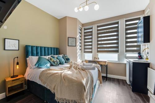 una camera con letto e testiera blu di Elegant Studio - Perfect for Explorers a Londra
