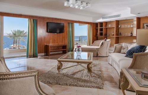 een woonkamer met een bank en een tafel bij Xperience Sea Breeze Resort in Sharm El Sheikh