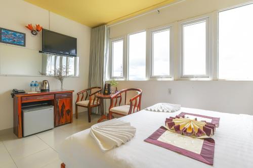 ダラットにあるMiền Nhiệt Đới 2 Hotelの大きな白いベッドとテーブルのある寝室