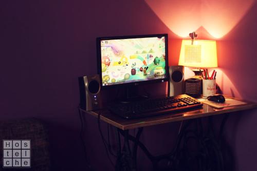 a desk with a computer monitor and a keyboard and mouse at HostelChe Hostel in Belgrade