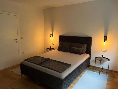 een slaapkamer met een groot bed en 2 tafels bij Apartment Vils Promenade in Sarajevo