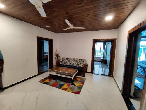 a living room with a couch and a ceiling fan at WhiteHouse Homestay by Oxystays Hospitality in Alibaug
