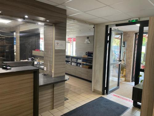 a lobby of a store with a counter and a glass door at Hotel du Triangle in Talange