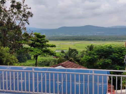 a view of a field from the balcony of a house at WhiteHouse Homestay by Oxystays Hospitality in Alibaug