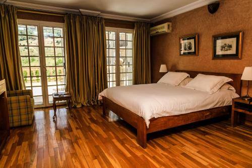 a bedroom with a large bed and windows at Le Palais des Cerisiers in Azrou