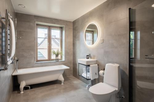 uma casa de banho com uma banheira, um WC e um lavatório. em Live and Stay Ekmanska em Gotemburgo