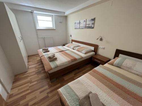 1 dormitorio con 2 camas y ventana en Apartma Slivnik, en Spodnje Gorje