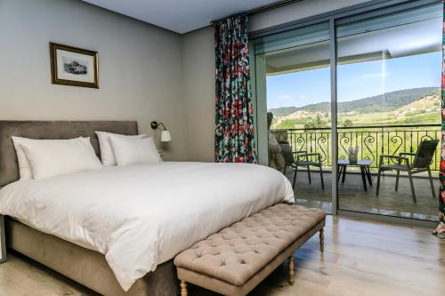 a bedroom with a large bed and a balcony at Le Palais des Cerisiers in Azrou